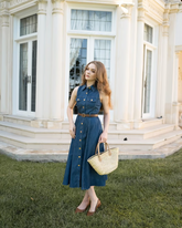 a lady wears a denim vest dress with a brown leather belt